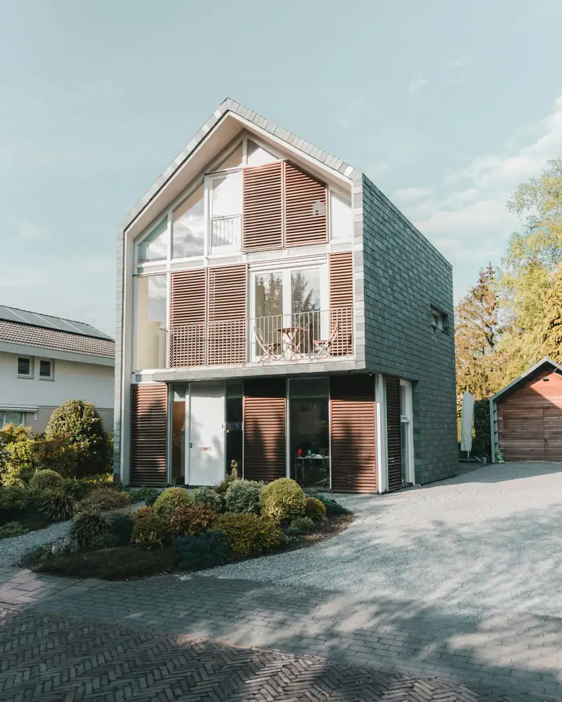 Maison contemporaine à pignon, grandes baies vitrées et volets en bois